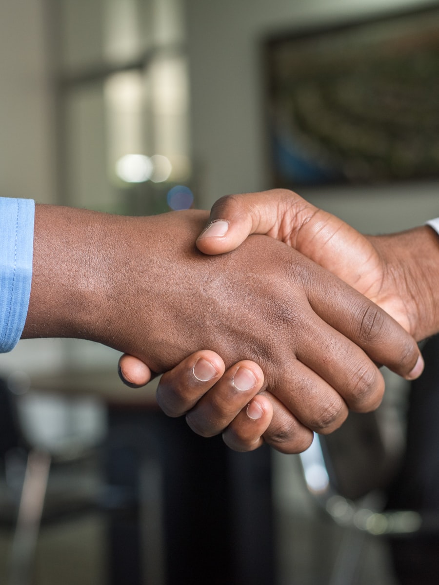 A warm handshake between a Spotto Finance mortgage broker and a client in a modern office