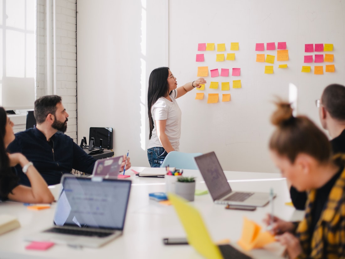 A diverse Spotto Finance team collaborating around a table in a bright, modern office