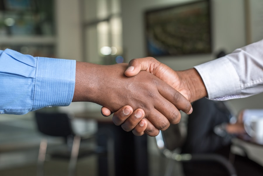 Two people shaking hands in an office, representing an honest, no-fee partnership