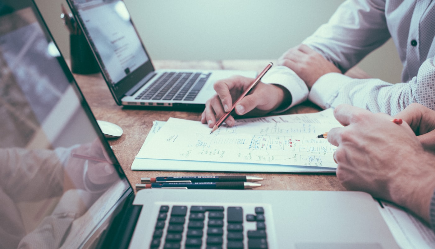 A Spotto Finance broker walking a client through home loan options and paperwork at a desk